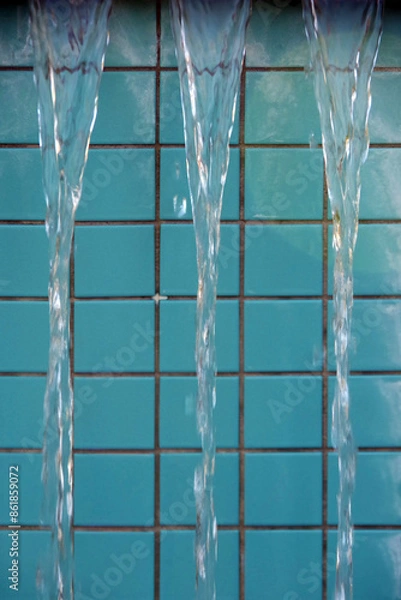 Fototapeta Water cascading over the edge of a turquoise tiled fountain