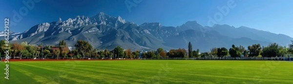 Obraz Green field with mountain range in the background.