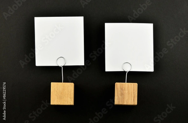 Fototapeta Two paper notes with holders on black background presentation