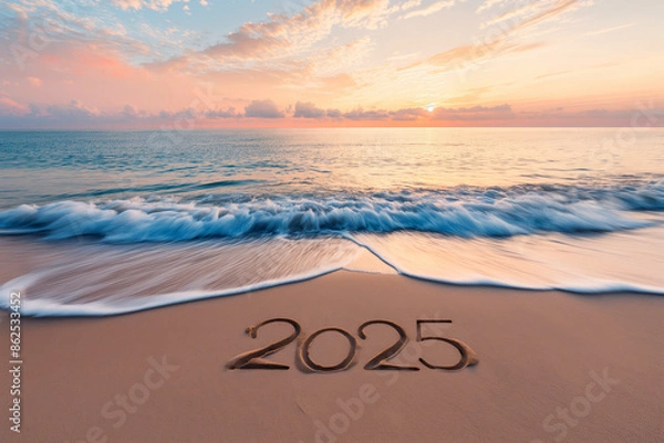 Obraz The year 2025 etched in the sand with waves washing ashore at sunset.