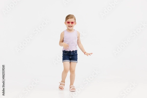 Fototapeta Happy smiling child having fun on white studio background. The concept of childhood and childish emotions.