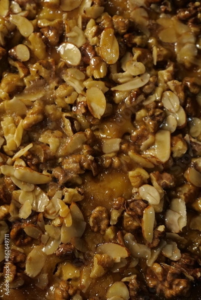 Fototapeta delicious tart with hazelnuts, almonds and caramel. pie with nuts. sweet pastry. close-up of a beautiful shiny cake