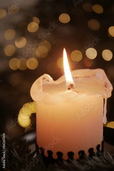 Obraz Christmas and New Year cozy  atmosphere. white candle in a black candlestick is burning against the background of blurry Christmas tree garlands. candle flame
