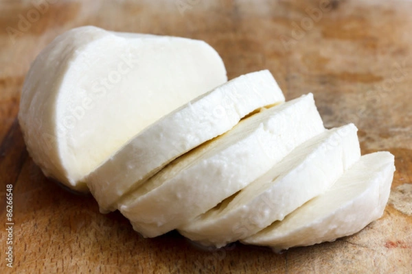 Obraz Pojedyncza kulka sera mozzarella w plasterkach i odizolowana na rustice