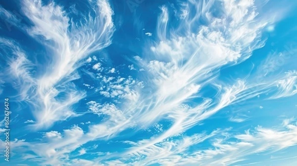 Fototapeta Cirrus clouds drifting across a blue sky in summer nature scene