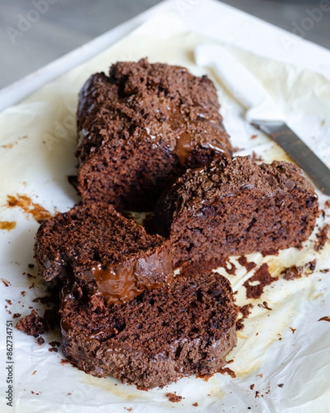 Obraz Chocolate cake cut into pieces lying on baking parchment. Clouse-up Chocolate cake slice.