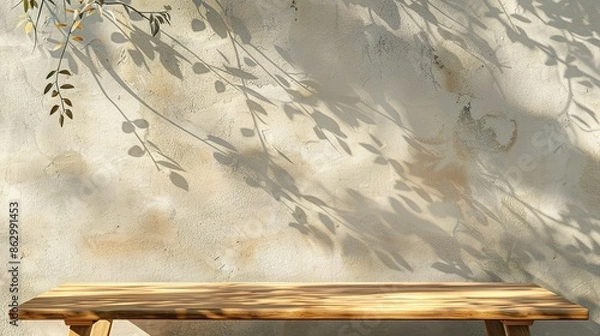 Fototapeta beige wall with texture and tree shadows, wooden table against the wall
