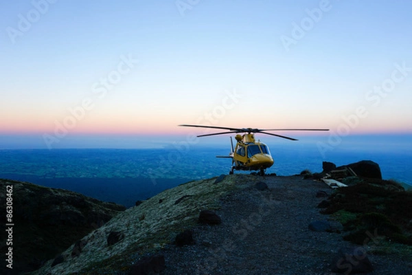 Obraz Helicopter on mountain peak at sunset