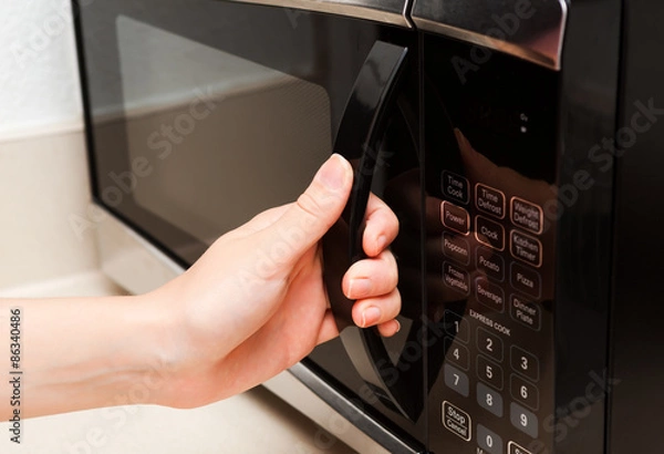 Obraz Hand opening microwave oven close up