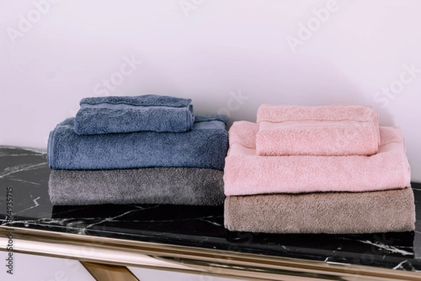 Fototapeta Spa, bathroom background. Stack of clean and folded towels. Bathroom and resort concept and interior accessories with copy space. Neutral beige colors.