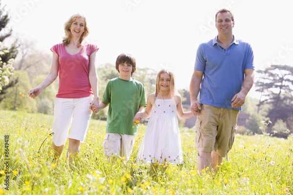 Fototapeta Family walking outdoors holding flower smiling