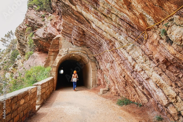 Fototapeta Traveler exploring a mountain track with a tunnel entrance on the coastline of Petrovac, Montenegro