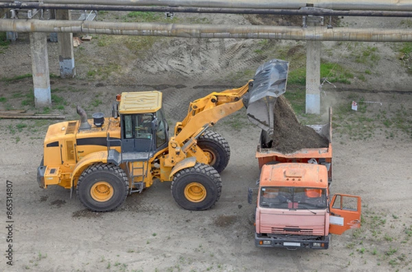 Fototapeta front loader loads gravel mixture into a dump truck