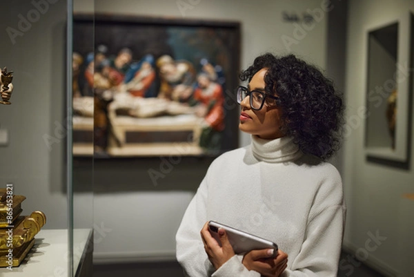Fototapeta Woman visitor in the historical museum looking at art object.