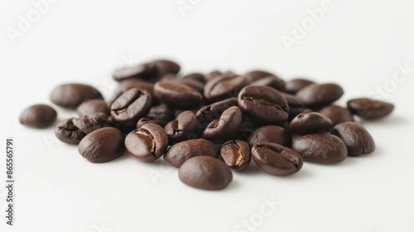 Fototapeta Small pile of whole coffee beans scattered on a smooth white surface