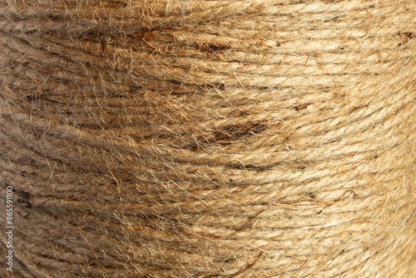 Fototapeta Close-up image of a natural jute twine spool, showcasing the rough, fibrous texture. The organic quality and intricate weave reveal the intertwined strands and fibers, highlighting the rope’s strength