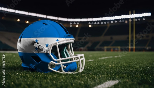 Obraz An American football helmet with the Honduras flag design sits on a field at night, under stadium lights