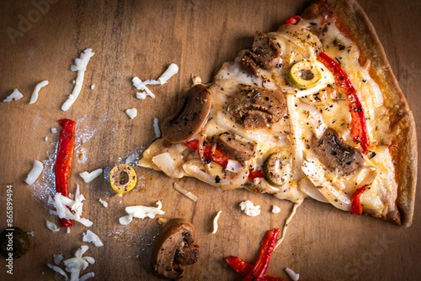 Obraz Close-up of a hand taking a slice of vegetarian pizza with onions, bell pepper, and vegetables on a wooden board.