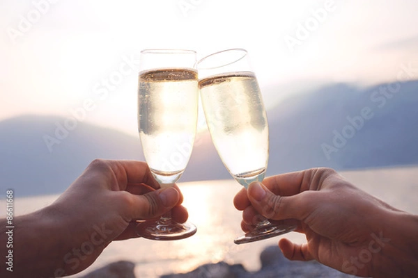 Fototapeta Lovers toast with wite wine at sunset