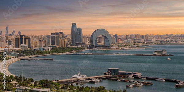 Fototapeta The Crescent Development Project features distinct modern architecture, including the Crescent Hotel, set against a beautiful sunset on the Caspian Sea coast in Baku, Azerbaijan