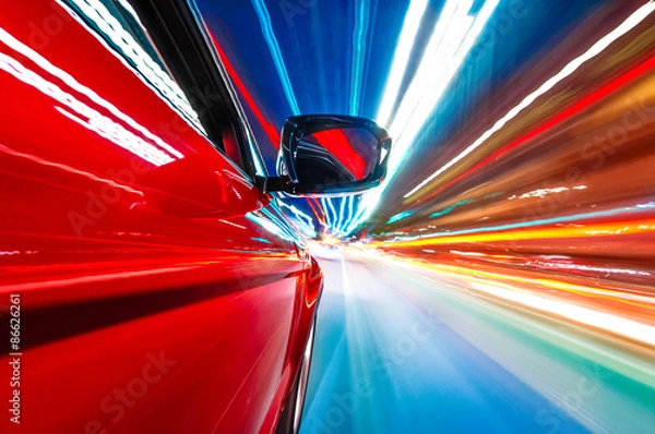 Fototapeta A car driving on a motorway at high speeds, overtaking other cars
