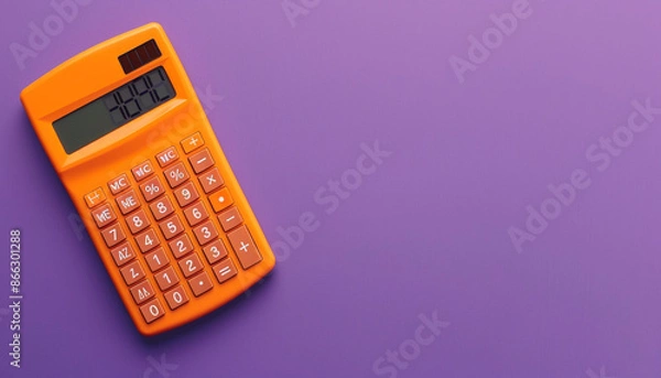 Fototapeta An orange calculator in the top left corner of a solid purple background, essential for math calculations.