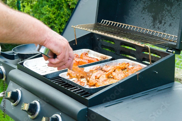 Fototapeta Grilling at the garden in summer weekend.