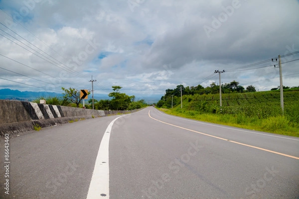 Fototapeta Winding Paved Road with cloud sky background