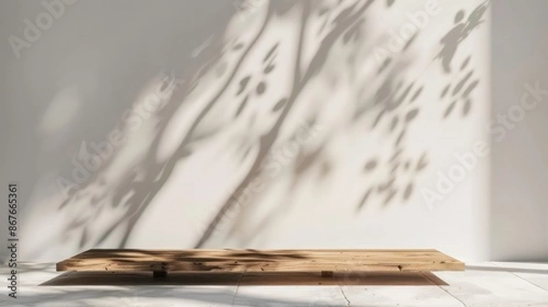 Obraz Empty copy space image of a wooden plank on a white wall background illuminated by sunlight casting a tree shadow Ideal for presenting products in a mockup scene