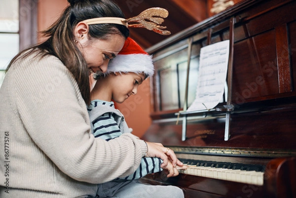 Fototapeta Mother, boy and piano at Christmas in home with smile, love or learning for music, performance or notes. Mom, child or son by keyboard for teaching, guide and helping for talent development at xmas