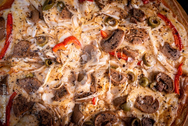 Obraz Close-up of a hand taking a slice of vegetarian pizza with onions, bell pepper, and vegetables on a wooden board.
