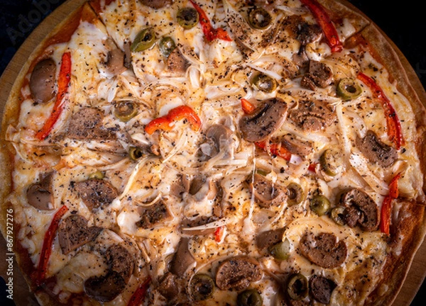 Obraz Close-up of a hand taking a slice of vegetarian pizza with onions, bell pepper, and vegetables on a wooden board.
