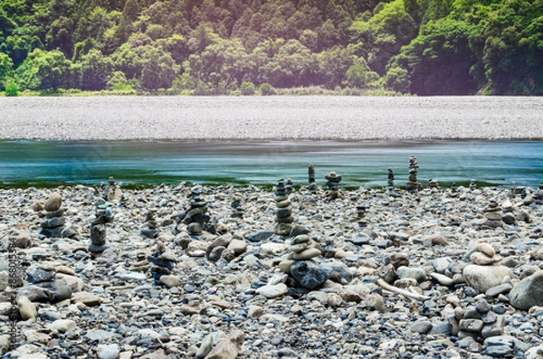 Obraz 川辺に石が積み上げられ三途の川のような風景が広がる熊野川