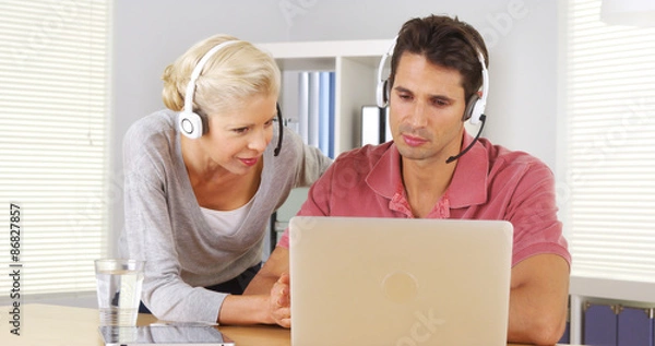 Fototapeta Two business colleagues having a video conference on laptop
