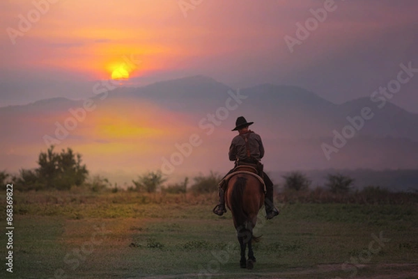 Fototapeta The silhouette of the cowboy and the setting sunset