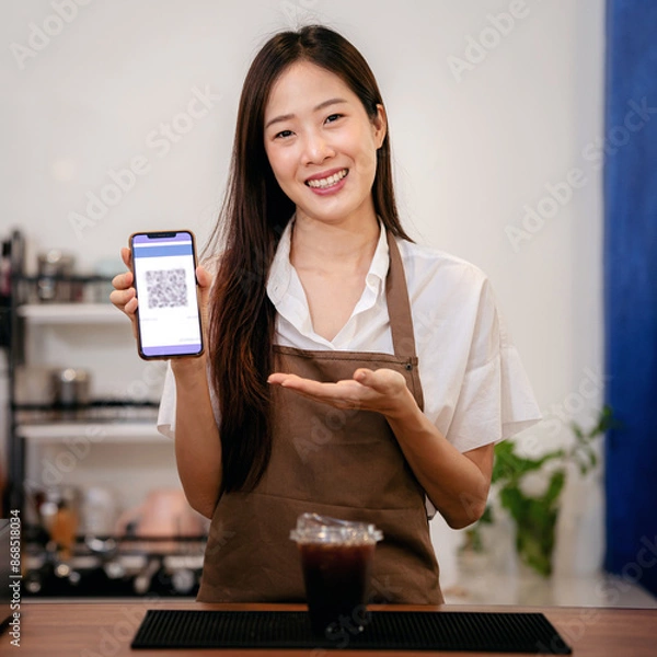 Obraz A woman is holding a phone with a QR code on it