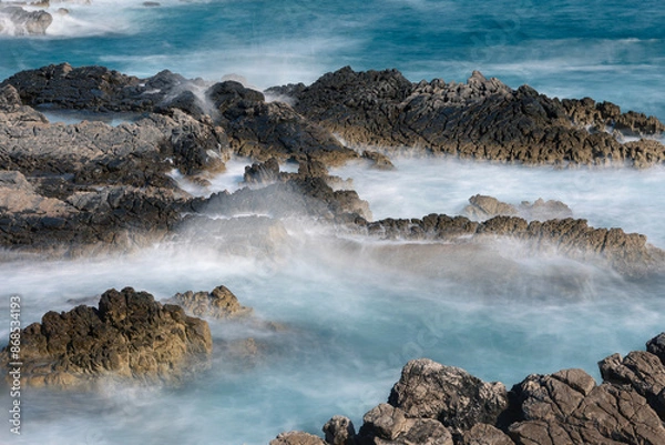 Obraz Long exposure shoot of sea waves crashing on seashore and rocks seascape.
