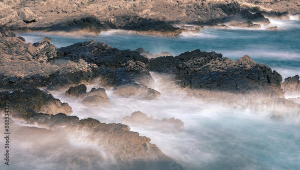 Obraz Long exposure shoot of sea waves crashing on seashore and rocks seascape.