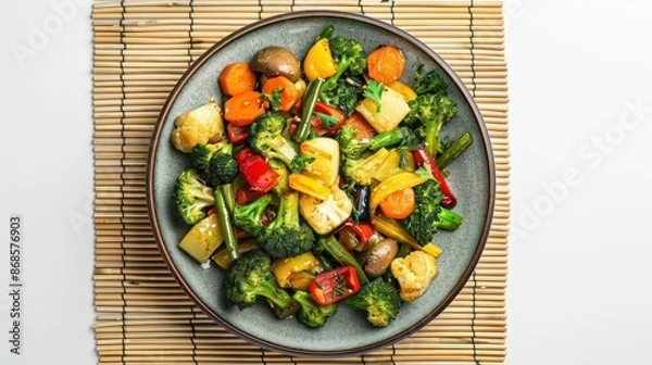 Obraz Vegan food ,Stir-Fried Vegetables ,vegetarian dish with mix of vegetables in plate on bamboo place mat on white background