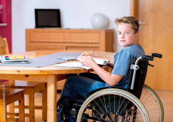 Obraz boy in wheelchair doing homework