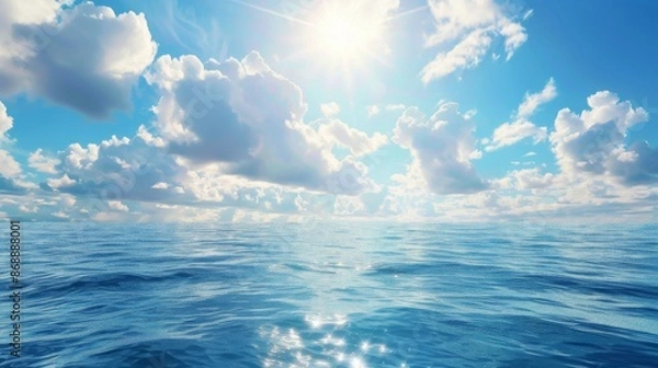 Fototapeta A sunlit ocean scene featuring shimmering waters and scattered white clouds against a deep blue sky, evoking a sense of warmth and peacefulness in the viewer.