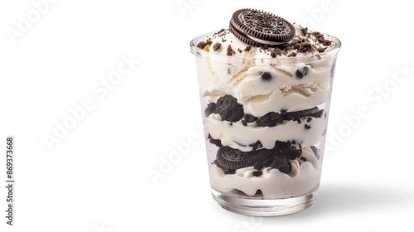 Fototapeta A glass filled with layers of chocolate cookies, creamy filling, and whipped cream, topped with a cookie