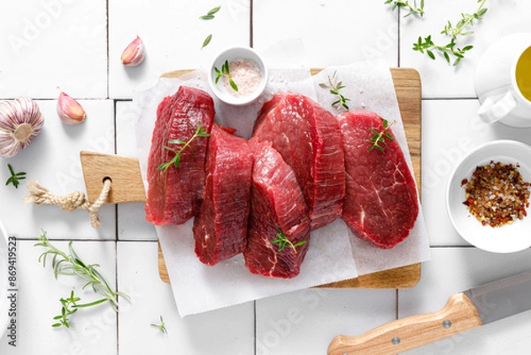 Fototapeta Beef. Raw beef tenderloin meat, beef steaks with ingredients for cooking. Top view