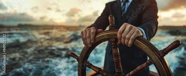 Obraz Businessman hands on ship's wheel, navigating through rough seas concept of leadership and marketing strategy business man in suit standing at the helm steering boat on blurred background