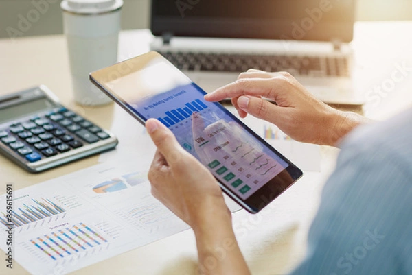 Fototapeta Businessman working on project for analyzing company financial report balance statement with dashboard at modern office space. Concept of business economy and marketing result.