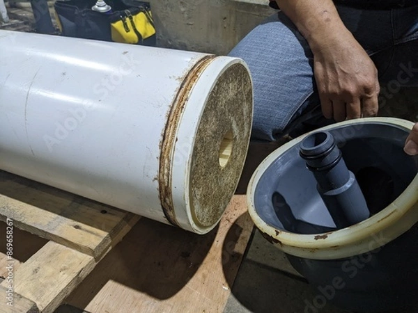 Obraz Inspection Water Ultra Filtration Membrane skid Maintenance. A close-up view of a water filter cylinder, featuring a white outer layer and a gray inner tube.