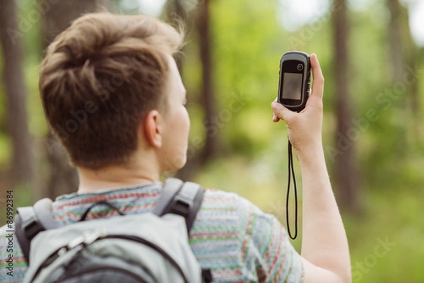 Obraz tourist  in the woods determines location using gps