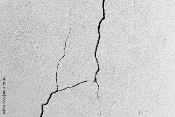 Fototapeta Crack in the wall. Cracks can be caused by soil movement, inadequate structural load, climate variations, natural wear and tear and even construction errors.