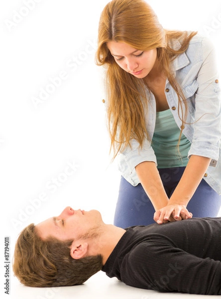 Obraz Couple demonstrating first aid techniques with woman applying cpr on male pattient lying down