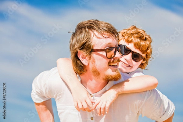 Fototapeta Hipster father with beard and red haired son having happy summer